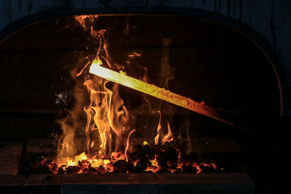Barre d'acier dans le feu de la forge